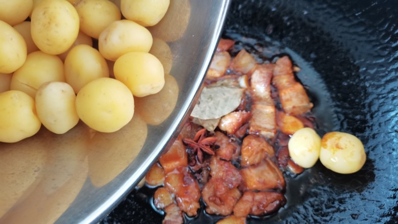 五花肉焖小土豆,放入香叶，花椒，茴香，倒入烧好的土豆炒匀