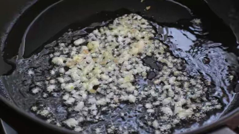 葱爆虾仁,锅中倒适量食用油烧至五成热，放入姜末和一半的蒜末小火炒香。