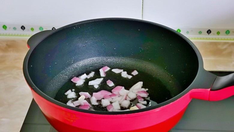杏鲍菇炒鸡丁,起油锅加入洋葱丁煸炒。