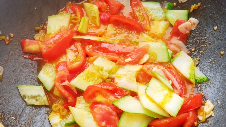 番茄黄瓜炒蛋,加入适量食盐和清水炒出汤汁。