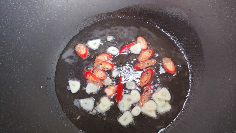 酸辣卷心菜,起油锅，油热后下大蒜片和小米椒，炒香