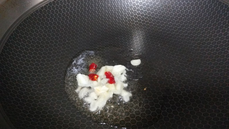 酸辣卷心菜,锅中倒入适量油烧热放蒜末炒香在放干辣椒。