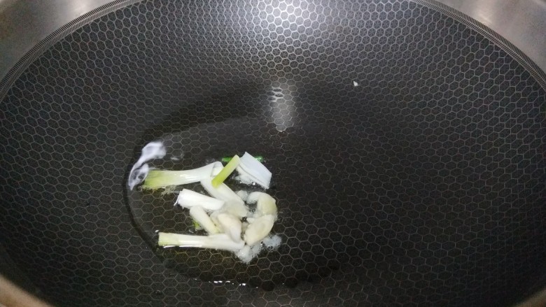 白菜炒蘑菇,锅中倒入适量油烧热，把葱白放入锅中炒香。