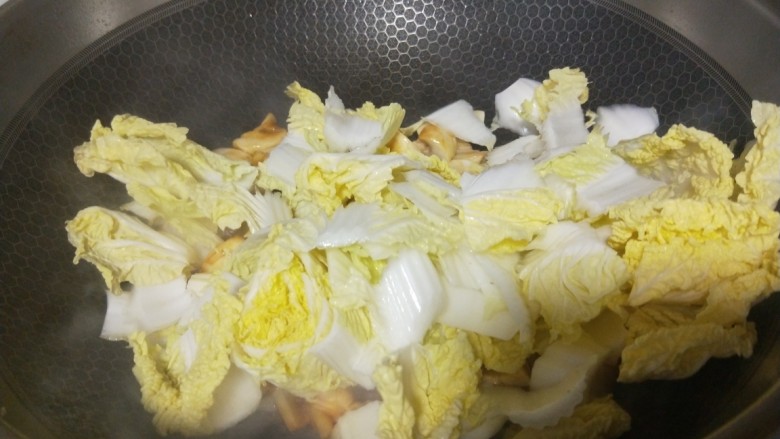 白菜炒蘑菇,倒入白菜炒均匀。