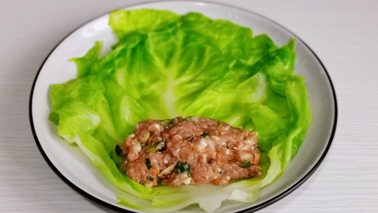 蔬菜卷,取一片菜叶放上适量的肉馅儿。