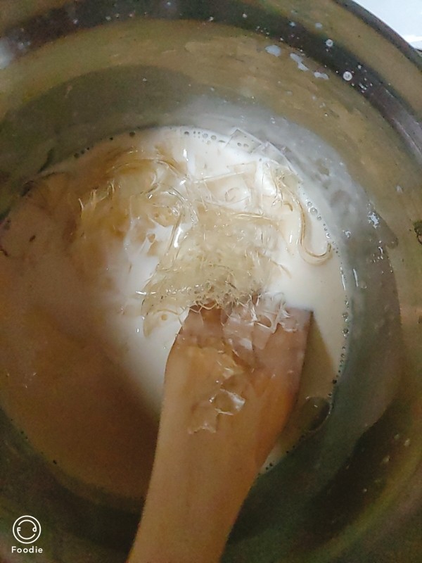 自制奶酪棒,吉利丁片放入牛奶芝士锅内，完全融化后准备倒出