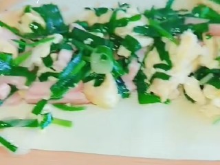 素卷三丝,把炒好的鸡蛋韭菜放入豆皮。