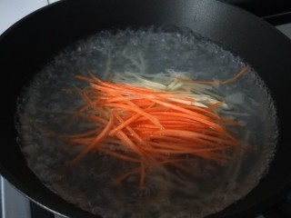 素卷三丝,水开倒入胡萝卜土豆丝。