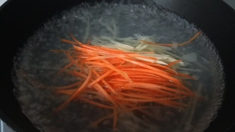 素卷三丝,水开倒入胡萝卜土豆丝。