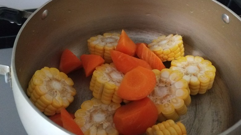 胡萝卜筒骨汤,玉米胡萝卜放入锅中。