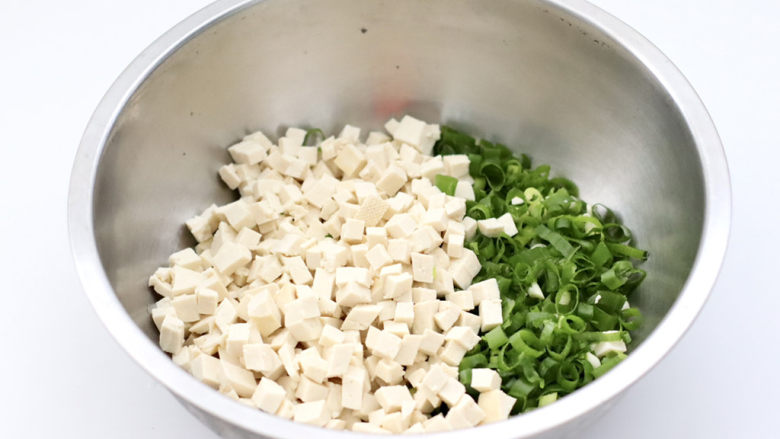 麻辣豆腐虾皮包,把切好的豆腐和葱末放入盆中。