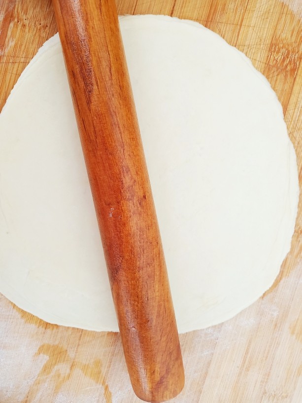 素卷三丝,用擀面杖将饺子皮擀成大大薄饼。