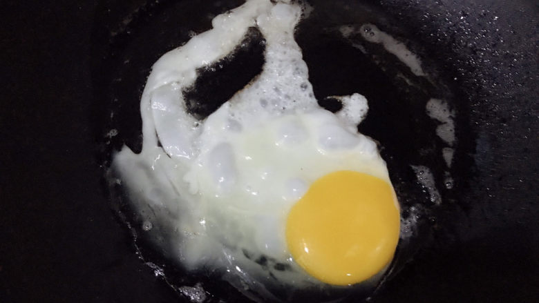 青菜鸡蛋面,鸡蛋打入锅中，煎成荷包蛋盛起备用
