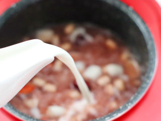 牛奶银耳百合汤,再打开锅盖，倒入牛奶搅拌均匀。