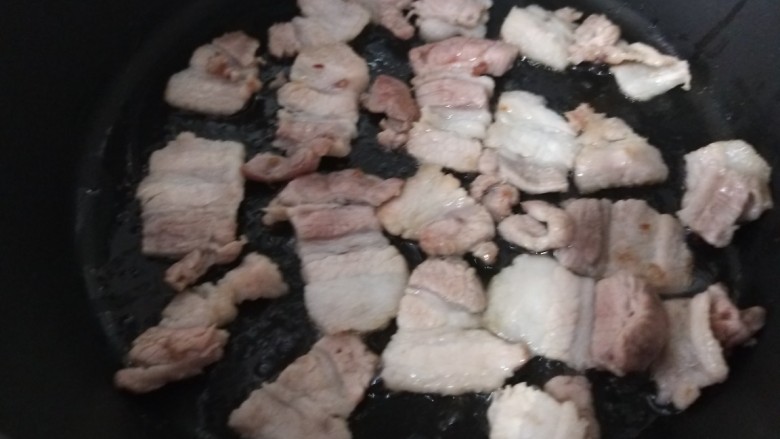 五花肉炒茭白,锅中倒入少许油倒入五花肉煸炒。