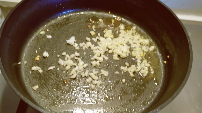 皮蛋炒青椒,锅中留下底油继续加热，放入蒜碎炒出香味。