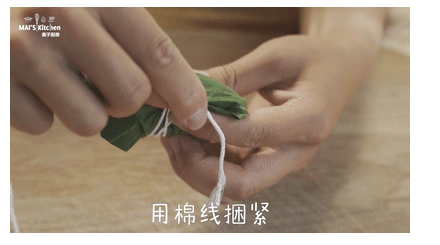 粽子一定要吃咸的|咸蛋黄肉粽最经典,将粽叶翻折包住粽子，用棉线将粽叶捆紧。