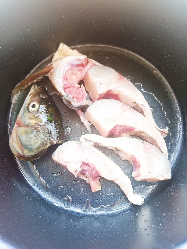 鱼头豆腐汤,锅中放少许油，加入鱼块小火慢慢煎一下。