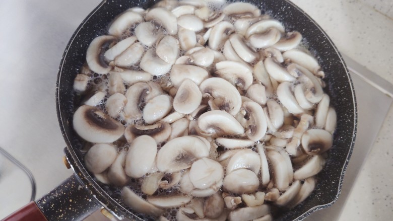 口蘑炒蛋,锅内煮适量清水，水开后倒入口蘑，煮一分钟