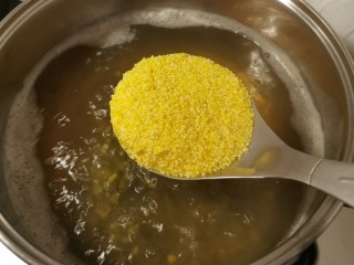 绿豆南瓜粥,放入小米和玉米碴继续熬煮。