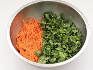 黑全麦芹菜团子,把切好的胡萝卜和芹菜叶放入盆中。