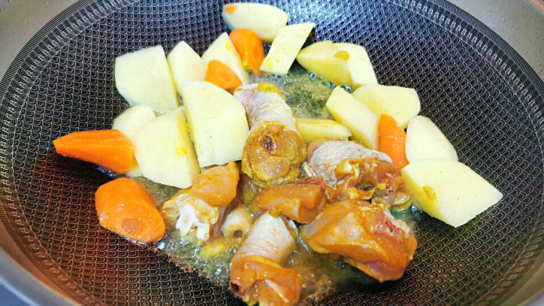 咖喱土豆鸡块,锅中下油，炒香鸡块与土豆，胡萝卜