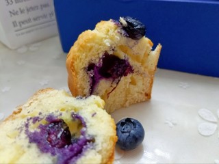 蓝莓酸奶马芬,出炉后晾凉，切开一个看看。中间的夹心蓝莓已经烤裂，出了一些蓝莓酱