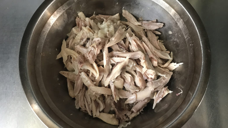 椒麻手撕鸡,取出鸡腿，用手把鸡肉撕下来，撕成长条放至盆中；卸下来的鸡骨可重新放回鸡汤中再炖一会儿，汤的味道更浓