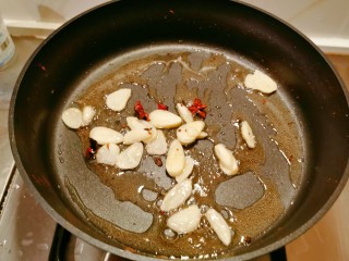 干锅菜花五花肉,干辣椒和麻椒取出，放入蒜片继续炒香。