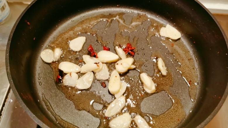 干锅菜花五花肉,干辣椒和麻椒取出，放入蒜片继续炒香。