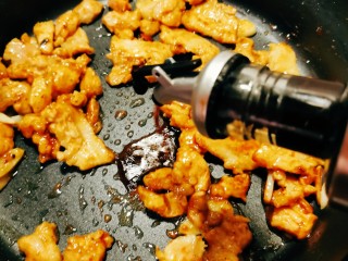 干锅菜花五花肉,倒入酱油提味。