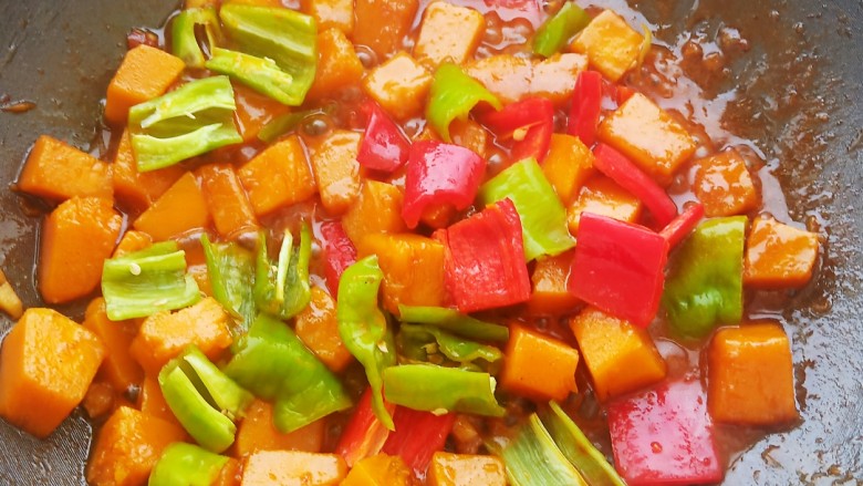 咸甜可口的酱烧南瓜,加入青红椒块和料汁再炖煮2分钟。