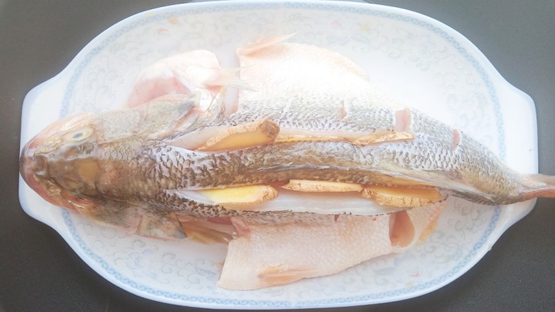 黄豆酱蒸鲈鱼,几分钟后，把腌料放在鱼肚子下面，水开上锅蒸10分钟。