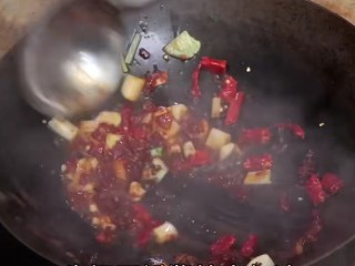 红烧草鱼块,倒入干辣椒段，郫县豆瓣酱炒红油。