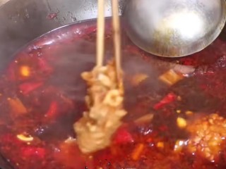 红烧草鱼块,先用筷子把鱼块加入锅中一半。