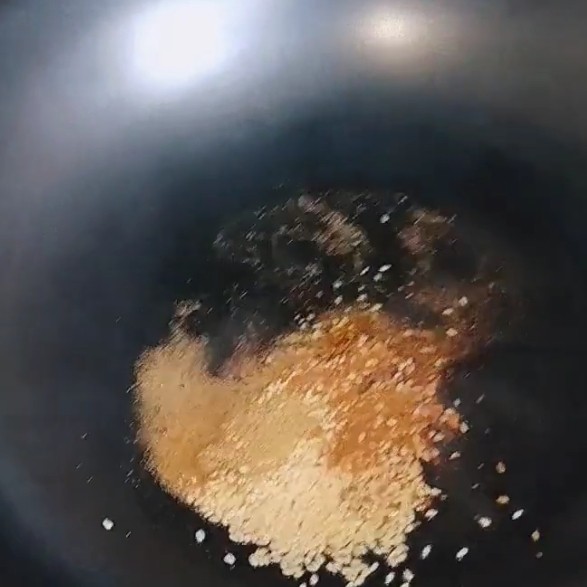 香炸锅巴肉,锅中倒入适量油炸制辣椒粉，白芝麻，倒入孜然粉。