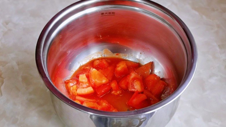 番茄排骨煲,首先把番茄炒出汤汁倒入饭煲中。