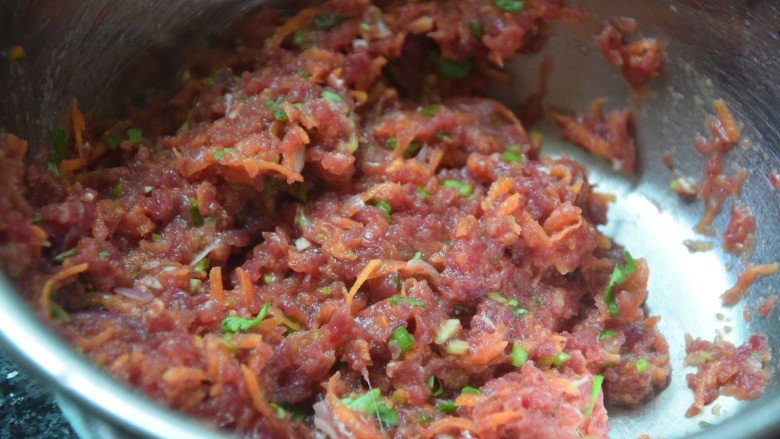 牛肉锅贴,将胡萝卜丝，香葱碎跟香菜碎倒入肉沫中，加入少许淀粉水拌成肉馅