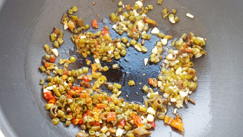 泡椒猪皮,锅中放10毫升食用油，加入泡椒泡豇豆和姜蒜爆香。