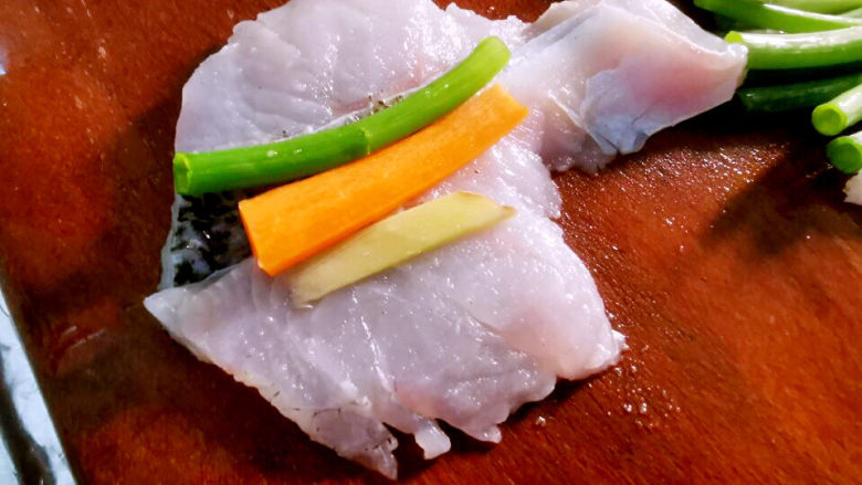 黄豆酱蒸鲈鱼,展开鱼片，包入葱姜，胡萝卜，卷紧