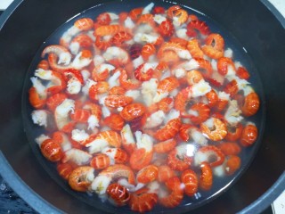 干煸小龙虾,冻龙虾尾自然解冻冲洗一下，锅里放水烧开，加入一勺料酒，下入虾尾焯水一分钟关火。