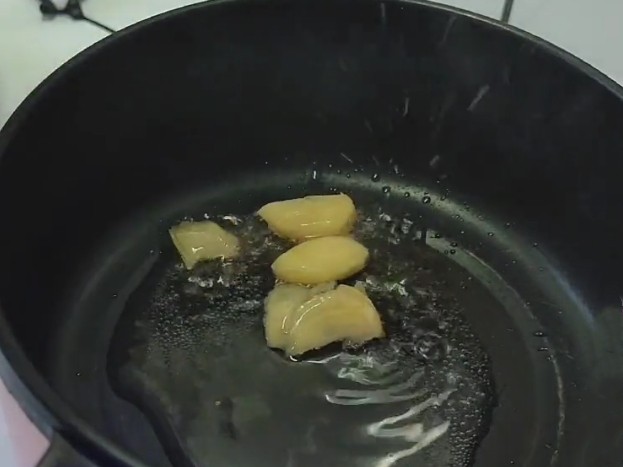 红烧鸭块,锅中倒入适量油炒姜片。