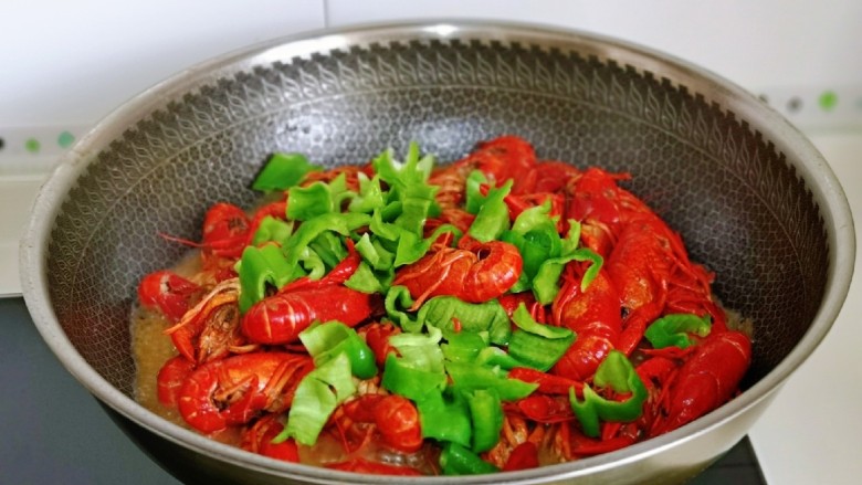 干煸小龙虾,加入切好的青椒，快速翻炒均匀，大火收汁至浓稠即可关火。(有点汤汁更好吃)