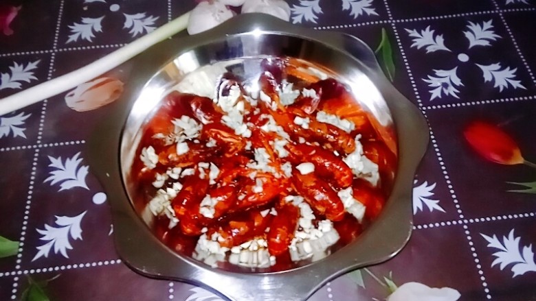 干煸小龙虾,撒上蒜粒，将干煸小龙虾端上餐桌。