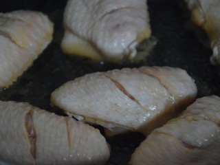 蒜香焖翅,起锅热油，放入鸡中翅煎至两边焦黄