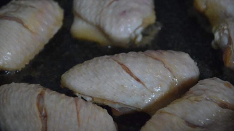 蒜香焖翅,起锅热油，放入鸡中翅煎至两边焦黄