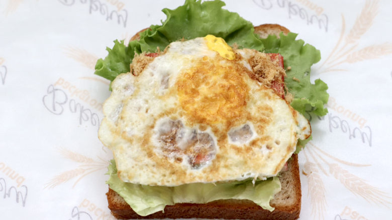 全麦蟹柳肉松鸡蛋三明治,铺上煎熟的鸡蛋。