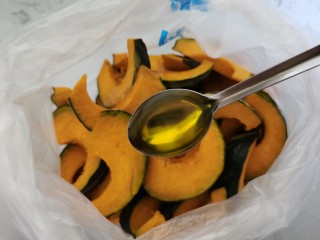 黑胡椒烤南瓜,切好的南瓜片放入口袋中，放一勺橄榄油