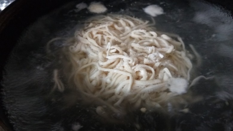 韩式冷面,锅中倒入适量水烧开下荞麦面。一半白面一半荞麦面制作的。
