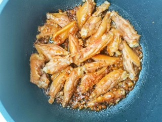 蒜香焖翅,将辣椒洗净切断，腌制好的鸡翅抹去蒜末,不粘锅倒适量油烧热，鸡翅下锅小火煎至金黄色，过程可以盖盖子焖一会儿